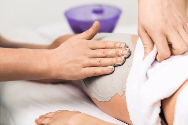Massage van benen met blauwe klei in spa. — Stockfoto