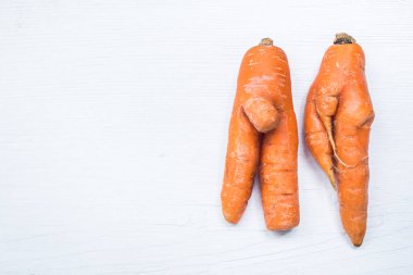 Havuç beyaz tahta arka plan üzerinde komik şekli. Erkek ve kız. Kopya alanı