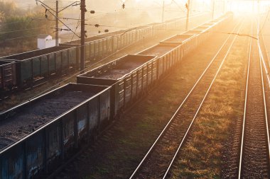 Yük trenleri olan demiryolları güneşin batışıyla güzelce aydınlatılıyor..