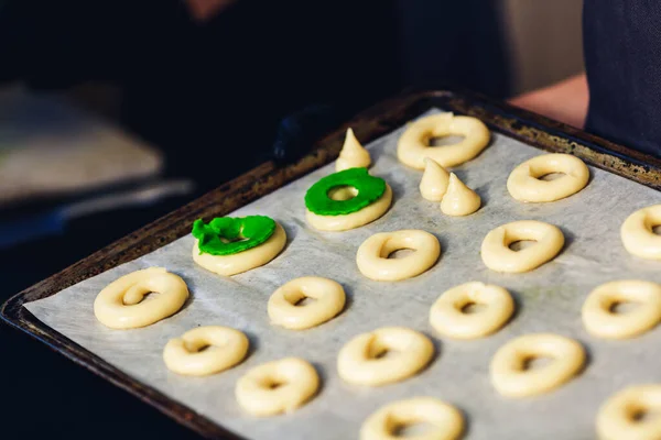 Raw eclairs rings on paper on baking sheet. — Stock Photo, Image