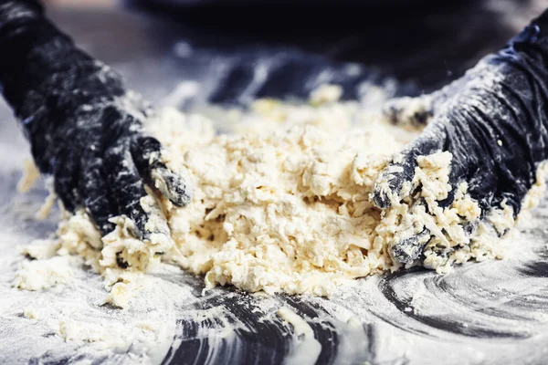 Baker's hands in black gloves knead the dough. — Stock Photo, Image