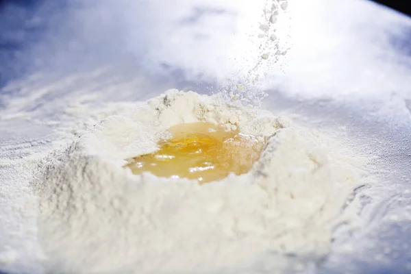 Flour with egg in middle. side view. — Stock Photo, Image