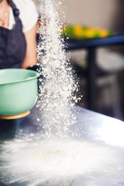 Fırıncı masanın üstüne un serper..