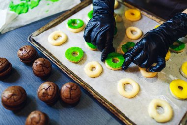 Pasta şefi çiğ profiterolleri yeşil ve sarı kısa hamur işiyle süslüyor..