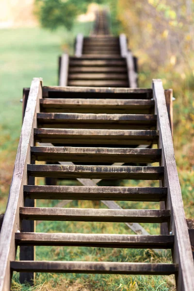 Venkovní dřevěné schodiště bez zábradlí jít nahoru na kopec. — Stock fotografie