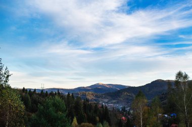 Dağların üstündeki mavi gökyüzü ağaçlarla kaplı. sirostratus bulutları