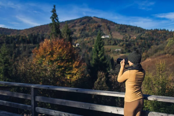 Vacker kvinna fotograferar naturen på berget på hösten. — Stockfoto