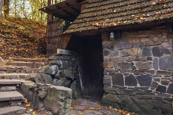Stary kamienny granitowy dom ze schodami na zboczu jesiennego lasu. — Zdjęcie stockowe