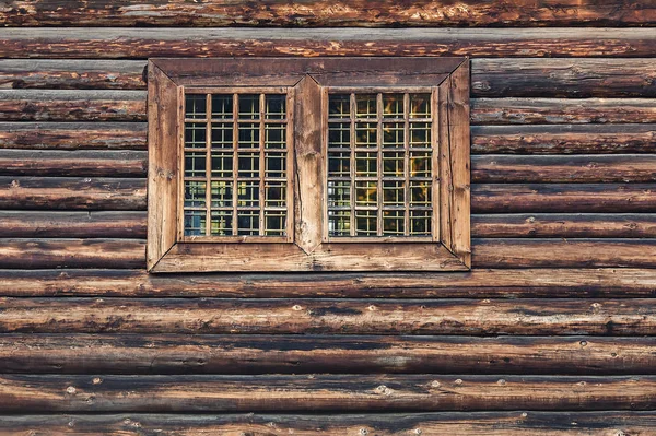 Fönster med galler i ett gammalt timmerhus. — Stockfoto