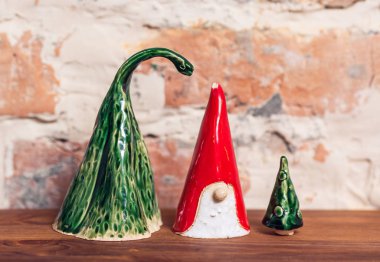 Cücenin seramik figürleri, tuğla duvardaki Noel ağacı. El yapımı..