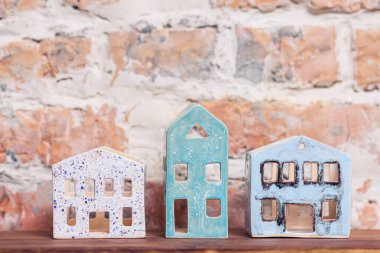 Çatısı olmayan tuğla duvarlı evin seramik figürleri.