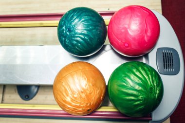 Bowling kulübünün rafında çok renkli bowling topları var..