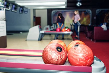 Bowling kulübünün rafında çok renkli bowling topları var..