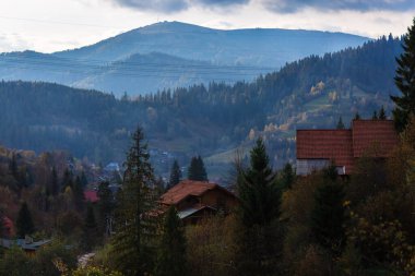 Dağlar arasında dumanlı köy manzarası