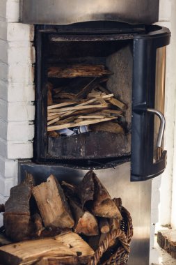 Kompozisyon, odun, soba malzemeleri, sepet. Gerçek şömine odun dolu.