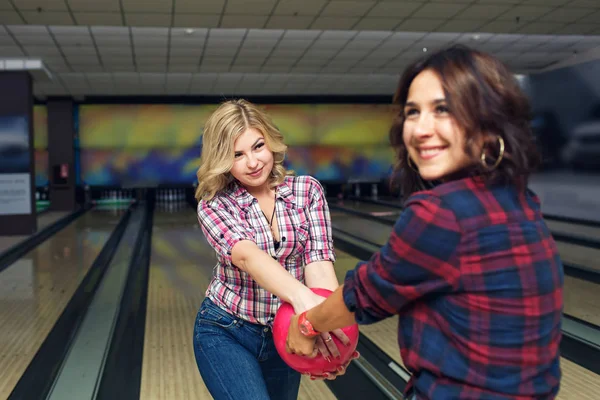Dvě Vtipné Dívky Chňapnout Bowling Koule Sebe Navzájem — Stock fotografie