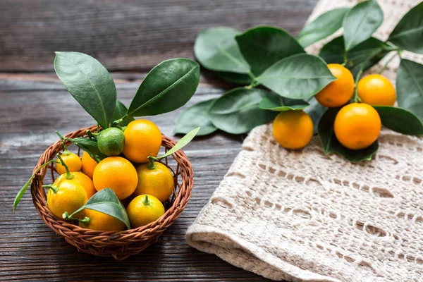 Citrus Calamondin Met Bladeren Mand Linnen Servet Houten Plank — Stockfoto