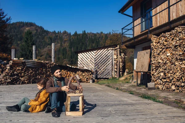 dad and daughter together build toy log house on outdoors on terrace