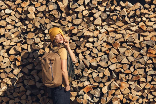 Turist Flicka Poserar Med Ryggsäck Bakgrund Stack Ved — Stockfoto