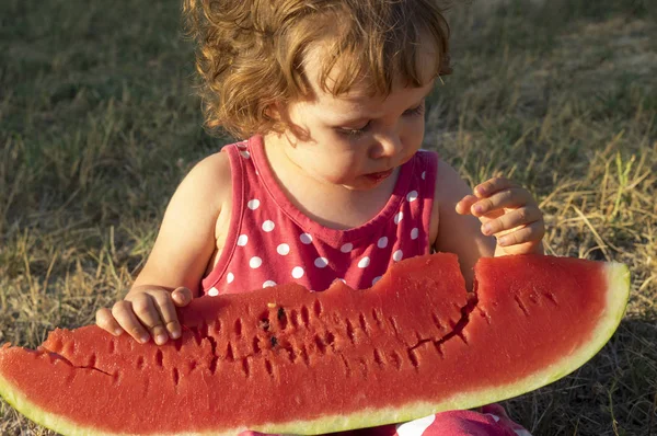 Lány eszik óriás szelet érett görögdinnye — Stock Fotó