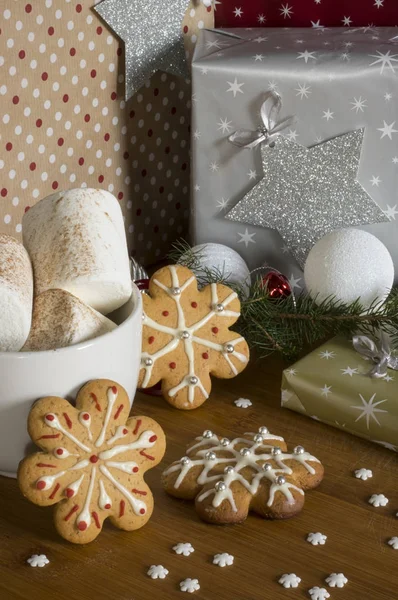 Gingerbread cookies on christmas presents background with marshm — Stock Photo, Image