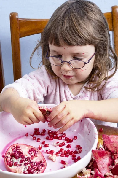 Giovane ragazza spremendo succo di melograno, facendo un pasticcio — Foto Stock