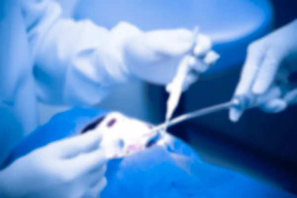 Dentista e assistente indossando guanti che lavorano con i denti mentre paziente bocca aperta, offuscata — Foto Stock