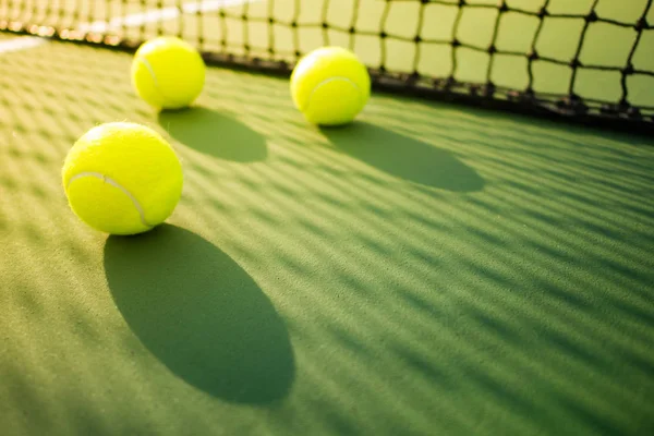 Drie tennisballen op groene harde rechter — Stockfoto