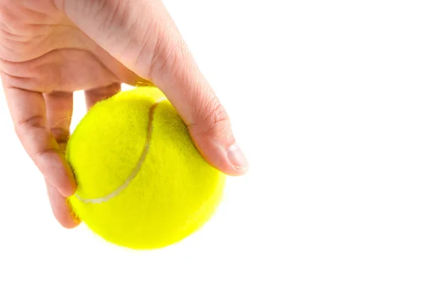 Vänster hand håller nya gul tennisboll på vit bakgrund — Stockfoto