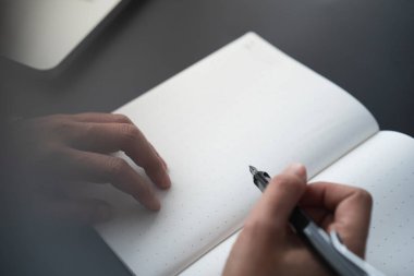 Not defterine yazmak için elinde kalem tutan işadamı
