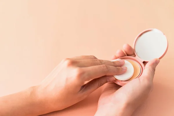 Ασιάτισσα γυναίκα χρησιμοποιώντας compact foundation powder and puff to makeup σε δέρμα προσώπου, φωτεινό φόντο κρέμας — Φωτογραφία Αρχείου