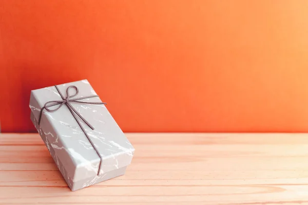 Caja de regalo de mármol en textura de paleta de madera y fondo naranja con espacio de copia a la derecha, presente para el concepto de los hombres —  Fotos de Stock