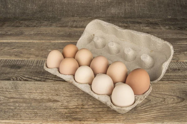 Ovos em uma bandeja em um fundo de madeira — Fotografia de Stock