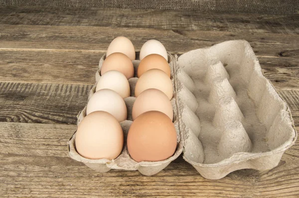 Ovos em uma bandeja em um fundo de madeira — Fotografia de Stock