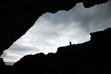 Aşık bir çiftin silüeti Deniz kenarındaki bir kayanın üzerinde