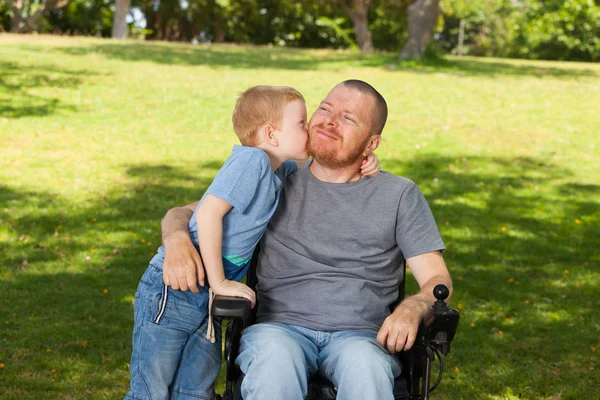 Little son kissing his disabled father. — Stock Photo, Image