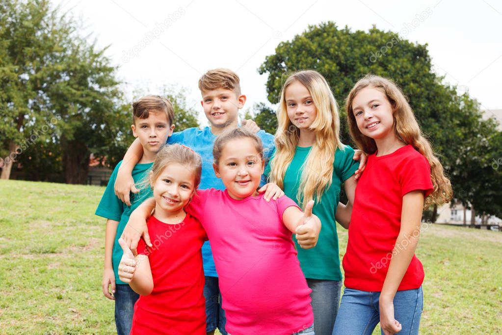 Group of happy kids showing thumbs up