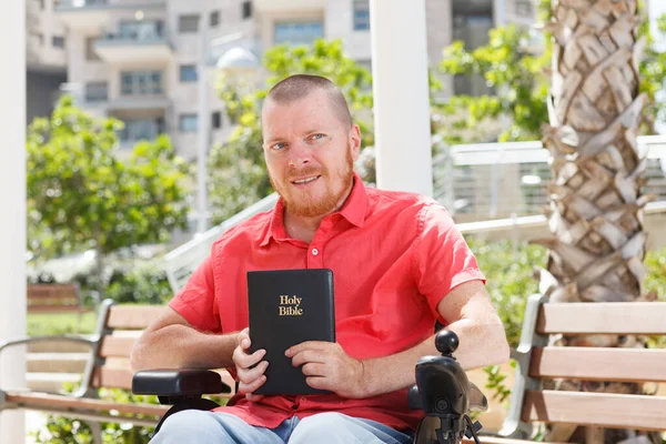 坐在轮椅上的残疾人手中的圣经 — 图库照片