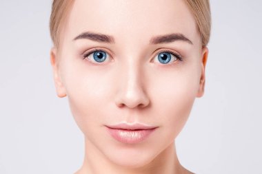 Güzel kadın portre yüz. Güzellik Portresi. Güzel Spa modeli mükemmel taze temiz ten kızla. Sarışın kadın gri arka plan kameraya bakıyor. Gençlik ve cilt bakım kavramı.
