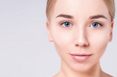 Güzel kadın portre yüz. Güzellik Portresi. Güzel Spa modeli mükemmel taze temiz ten kızla. Sarışın kadın gri arka plan kameraya bakıyor. Gençlik ve cilt bakım kavramı.