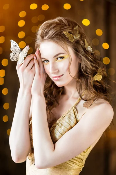 Atrakcyjny Młody Model Kręconą Fryzurą Złotymi Motylami Uśmiechnięty Żółtym Tle — Zdjęcie stockowe