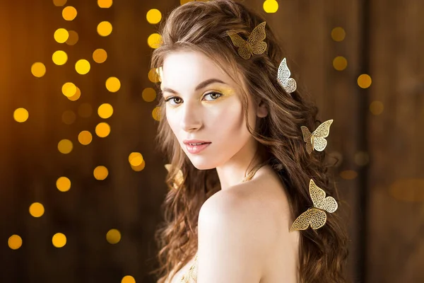 Młoda Elegancka Kobieta Złotymi Motylami Kręconych Włosach Żółtym Tle Bokeh — Zdjęcie stockowe