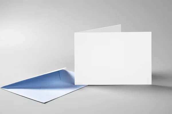 Prázdná Karta Modrou Obálku Šedé Pozadí — Stock fotografie