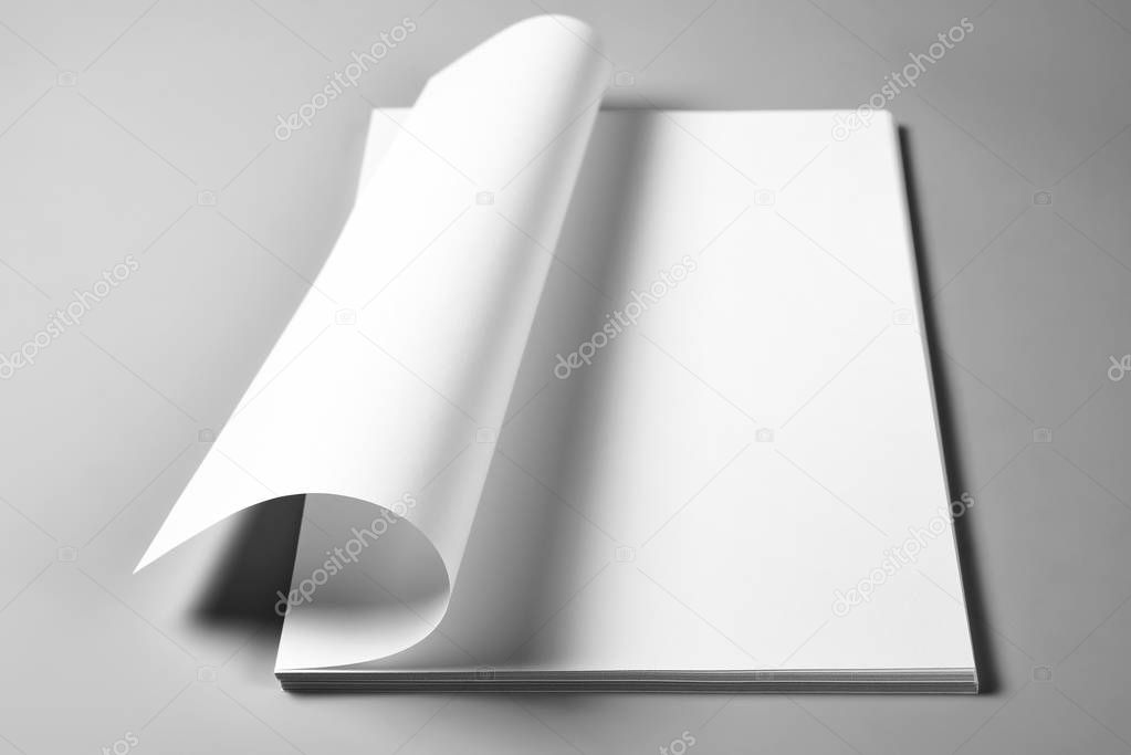 Pile of blank sheets of paper with curled upper page 