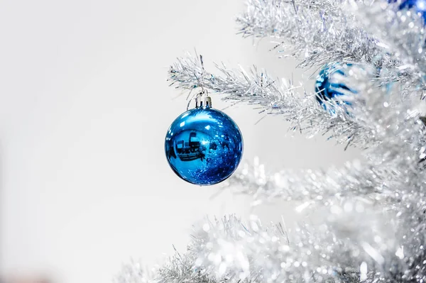 Blaue Kugeln auf silbernem künstlichen Weihnachtsbaum — Stockfoto