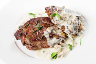 kavrulmuş dana biftek biberiye altında beyaz sos ile