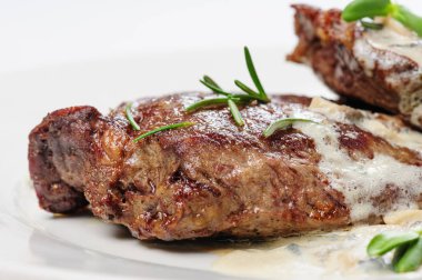 kavrulmuş dana biftek biberiye altında beyaz sos ile