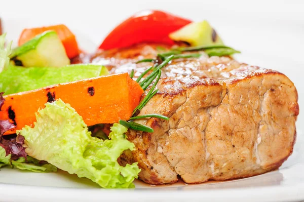 Grilované vepřové maso a zeleninu na talíř — Stock fotografie