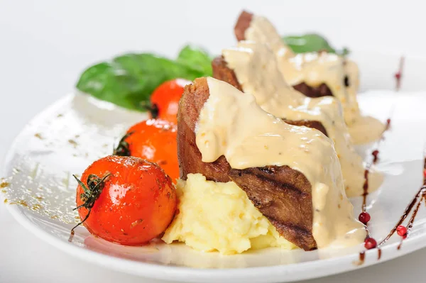 Viande de mouton cuite au four avec sauce crémeuse, purée de pommes de terre et tomates cerises — Photo