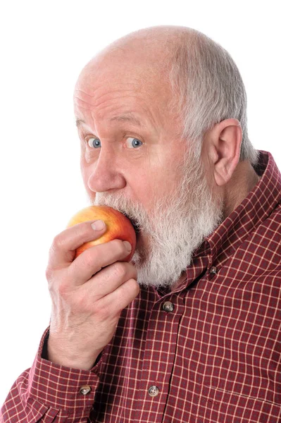 Cheerfull senior man eating the apple, isolated on white — Stock Photo, Image